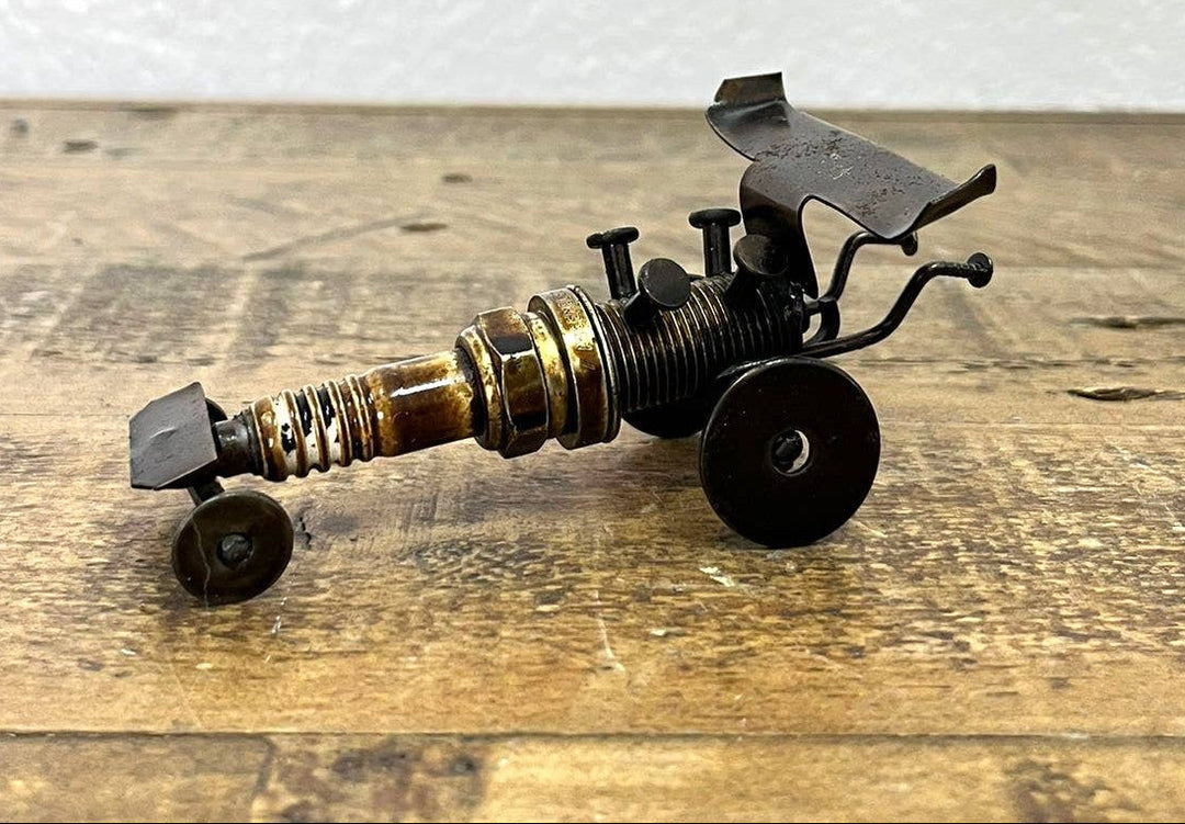Handmade Recycled Sparkplug Art. Made with Rustic recycled metal and may have visible scratches or imperfections due to their previous use. We strive to minimize these blemishes, but they are a natural result of the recycling process. Stocked at our Smyrna, TN shop close to the Nissan plant.

* 2" H x 4" L x 2" W