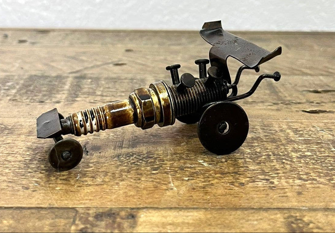 Handmade Recycled Sparkplug Art. Made with Rustic recycled metal and may have visible scratches or imperfections due to their previous use. We strive to minimize these blemishes, but they are a natural result of the recycling process. Stocked at our Smyrna, TN shop close to the Nissan plant.

* 2" H x 4" L x 2" W