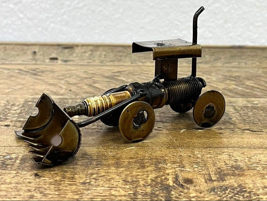 Handmade Recycled Sparkplug Art. Made with Rustic recycled metal and may have visible scratches or imperfections due to their previous use. We strive to minimize these blemishes, but they are a natural result of the recycling process. Stocked at our Smyrna, TN shop close to the Nissan plant.

* 2" H x 4" L x 2" W