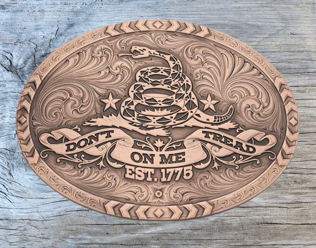 The 1776 Declaration is a Vintage Bronze Gadsden Belt Buckle. This oval buckle features a bronze tone finish. The words "Don’t Tread on Me" are featured prominently on curling ribbon at the bottom of the buckle. The Gadsden rattle snake sits ready to strike in the center of the buckle for a bold look. Chevron designs border the top, bottom, and sides giving the buckle a militant feel. Approx 4"x3" Standard 1.5 inch belt swivel. Get yours at our local Smyrna, TN not far from Nashville.