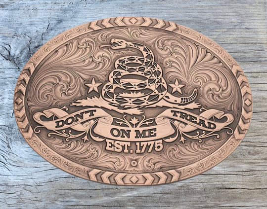 The 1776 Declaration is a Vintage Bronze Gadsden Belt Buckle. This oval buckle features a bronze tone finish. The words "Don’t Tread on Me" are featured prominently on curling ribbon at the bottom of the buckle. The Gadsden rattle snake sits ready to strike in the center of the buckle for a bold look. Chevron designs border the top, bottom, and sides giving the buckle a militant feel. Approx 4"x3" Standard 1.5 inch belt swivel. Get yours at our local Smyrna, TN not far from Nashville.