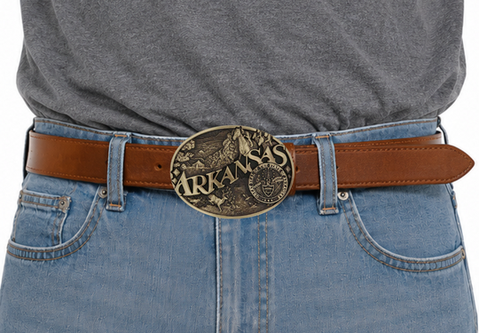 Large lettering spelling out Arkansas stretches boldly across, surrounded by a set of antiqued figures in celebration of Arkansas heritage including horse racing, wildlife, and the state seal. Our cast belt buckles are acid washed to add the dark antiqued patina and hand buffed to bring out the highlights and details. Standard 1.5 inch belt swivel.
&amp;nbsp;Get yours at our local Smyrna ,TN shop.
Width 3.75 Height 2.75
Materials Brass plate over a solid cast metal alloy base