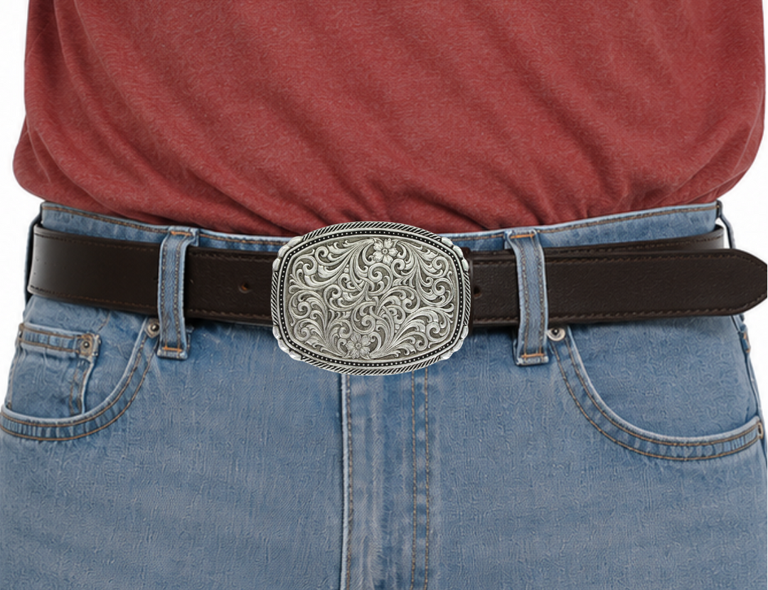 This buckle features a beautiful Intricate Classic Western Scroll pattern as the main design. Its antiqued curved rectangular shape is accented with twisted silver finished rope edging and high-domed beads, framing the bright cut Western scroll design. It can fit a standard 1.5 inch belt and measures approximately 3 3/4"" across x 3" tall. You can find it at our Smyrna, TN location, just a short drive from downtown Nashville. Made by Montana Silversmith.