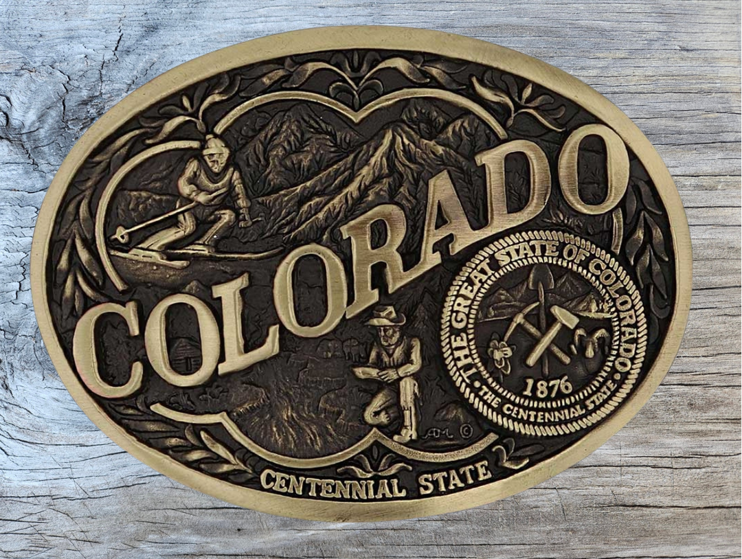 Celebrate Iowa State with this buckle highlighting corn, farming, wrestling, and a church motifs, including the great state seal! Brass plate over a solid cast metal alloy is antiqued and buffed to highlight the details.

Fits 1 1/2" belts and is approx. 3" tall x 4" across. Available at our shop just outside Nashville in Smyrna, TN. Made by Montana Silversmiths.