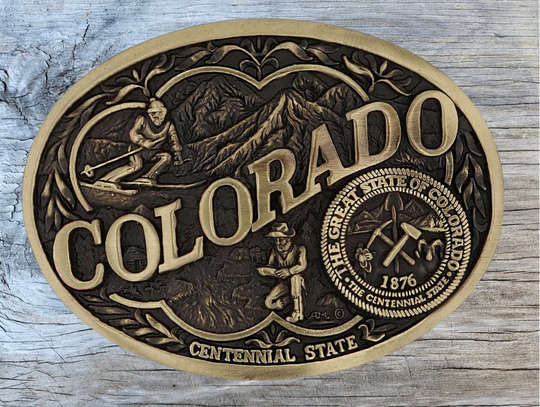 Celebrate Iowa State with this buckle highlighting corn, farming, wrestling, and a church motifs, including the great state seal! Brass plate over a solid cast metal alloy is antiqued and buffed to highlight the details.

Fits 1 1/2" belts and is approx. 3" tall x 4" across. Available at our shop just outside Nashville in Smyrna, TN. Made by Montana Silversmiths.