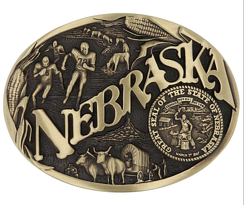 Celebrate Nebraska State with this oval buckle highlighting football, corn, pioneers, and the great state seal! Brass plate over a solid cast metal alloy is antiqued and buffed to highlight the details.

Fits 1 1/2" belts and is approx. 3" tall x 4" across. Available at our shop just outside Nashville in Smyrna, TN. Made by Montana Silversmiths.