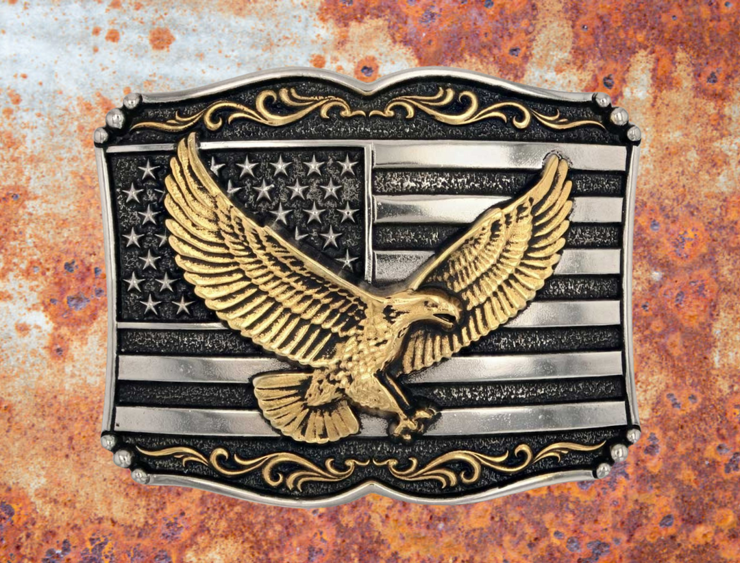 Soar with pride when you attach this stunning buckle to a favorite belt. The Soaring Liberty Attitude Buckle is expertly crafted from Silver and gold over a white metal alloy with painted accents with the American flag and bald eagle. This buckle celebrates the American spirit and pride. It&