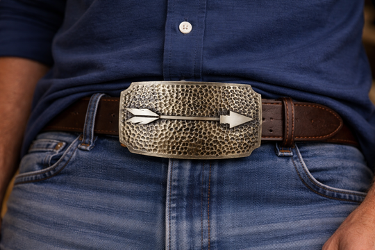 A Primal Arrow was a go-to weapon for hunting and defense, showing focus, strength, and skill. Featuring a hammered backdrop with a feathered arrow as the centerpiece. Each corner of this rectangle buckle appears to have been scooped out. Make a statement with this simple yet classic buckle, a great complement to many styles. Measuring about 2 1/2"x 3 3/4", it suits belts up to 1 3/4" wide. Swing by our Smyrna, TN shop to grab yours!
