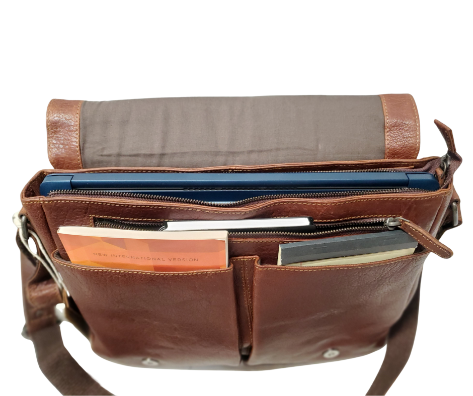 The General Leather Messenger Bag is perfect for the working week, with a traditional style and soft pebble grain leather that only improves with use. It features a main zippered pocket for your laptop, paperwork, and even some snacks, along with two side pockets secured by magnetic clasps for power cords. Plus, the adjustable shoulder strap and back strap make it perfect for any travel needs. Swing by our shop in Smyrna, TN and get yours today!