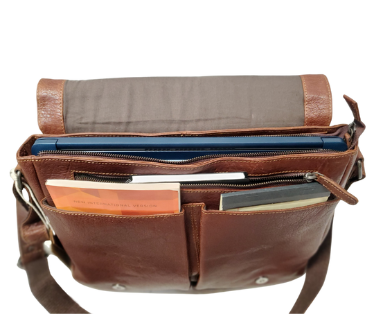 The General Leather Messenger Bag is perfect for the working week, with a traditional style and soft pebble grain leather that only improves with use. It features a main zippered pocket for your laptop, paperwork, and even some snacks, along with two side pockets secured by magnetic clasps for power cords. Plus, the adjustable shoulder strap and back strap make it perfect for any travel needs. Swing by our shop in Smyrna, TN and get yours today!