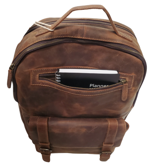 The Governor Leather Backpack is a Classic bag that can carry everything you need for a busy week. Crafted from Distressed leather that will gain a vintage look over time. It features 2 main zippered compartments, a laptop sleeve, space for documents. The magnetic clasp pocket in the front is perfect for power cords. Plus, the adjustable shoulder straps make for a comfortable fit. The back strap easily slides onto your carryon for stress-free travel. Swing by our Smyrna, TN location and snag yours today!