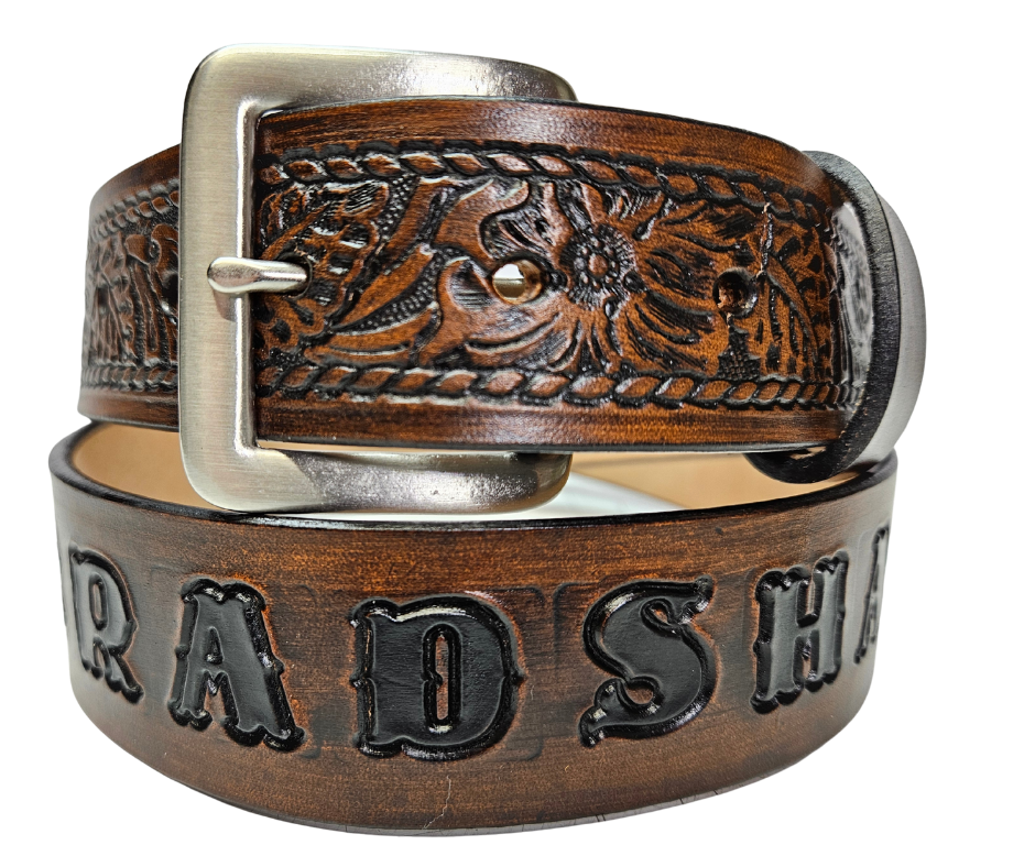 Our "The Ranch" Name Leather Belt can be personalized! It is Veg-tan leather belt, aptly named "The Ranch," with it's Western scroll pattern framed in a Rope edge border. Made in Smyrna, TN, close to Nashville. It's interchangeable solid brass buckle ensures convenience while maintaining high quality. Elevate any outfit with this stylish and versatile accessory.