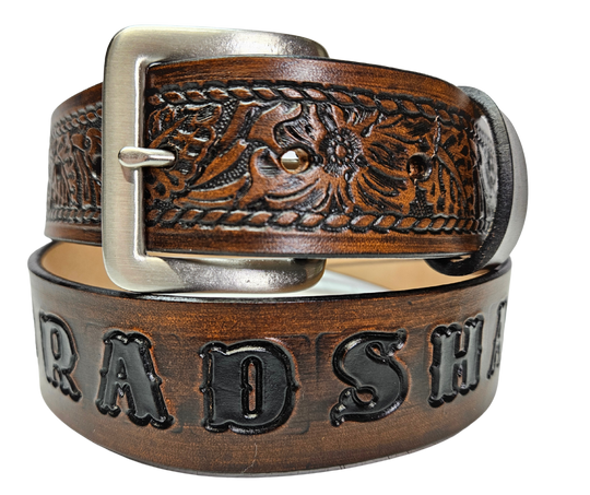 Our "The Ranch" Name Leather Belt can be personalized! It is Veg-tan leather belt, aptly named "The Ranch," with it's Western scroll pattern framed in a Rope edge border. Made in Smyrna, TN, close to Nashville. It's interchangeable solid brass buckle ensures convenience while maintaining high quality. Elevate any outfit with this stylish and versatile accessory.