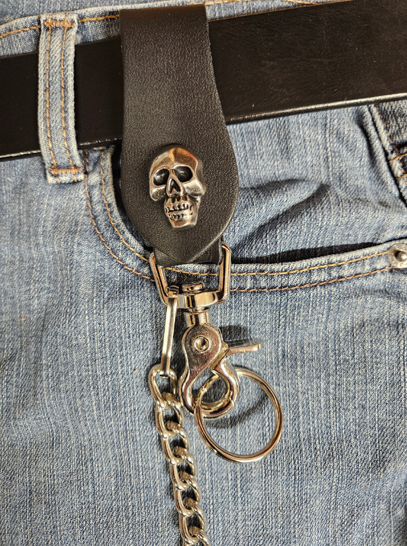 This Vintage style Steel Chain with a Skull Head Concho. Simple but Sturdy and will keep your wallet where it needs to be. The Leather loop, decorated with a Skull concho, attaches to your jeans and the split ring attaches to your wallet. Chrome plated. Ride down and get yours in our shop just outside Nashville in Smyrna, TN.

18" Chain Length
Leather belt tab
