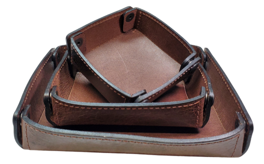 The Capitol Valet Travel Tray is our handmade valet tray is 1 layer of Water Buffalo leather. It's a little different than our other tray because it's more of a Rectangle/Square shape. The corners are held together with heavy line 24 Antique Brass colored snaps, for laying flat for travel, a place for placing keys, wallet, coins, etc. Made in our shop just outside Nashville in Smyrna, TN.

Small is Approx. 4"x 4"
Medium is approx. 4"x6"
Large is approx. 8"x 6"