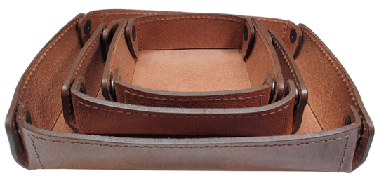 The Capitol Valet Travel Tray is our handmade valet tray is 1 layer of Water Buffalo leather. It's a little different than our other tray because it's more of a Rectangle/Square shape. The corners are held together with heavy line 24 Antique Brass colored snaps, for laying flat for travel, a place for placing keys, wallet, coins, etc. Made in our shop just outside Nashville in Smyrna, TN.

Small is Approx. 4"x 4"
Medium is approx. 4"x6"
Large is approx. 8"x 6"