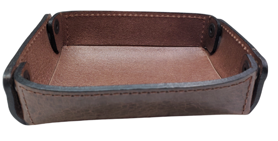 The Capitol Valet Travel Tray is our handmade valet tray is 1 layer of Water Buffalo leather. It's a little different than our other tray because it's more of a Rectangle/Square shape. The corners are held together with heavy line 24 Antique Brass colored snaps, for laying flat for travel, a place for placing keys, wallet, coins, etc. Made in our shop just outside Nashville in Smyrna, TN.

Small is Approx. 4"x 4"
Medium is approx. 4"x6"
Large is approx. 8"x 6"