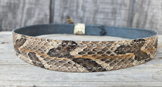 This Natural Copper Canyon Eastern Canebrake Rattlesnake Skin Hatband has a Rattle at the end of the band. It has more a Striped Copper pattern than a traditional Diamondback. Actual snakeskin with a pigskin backing and adjustment with a Velcro loop that you can tighten or loose to fit your favorite hats. You can bring your hat and try them out if you come to our Smyrna, TN shop not far from Nashville.

1" width