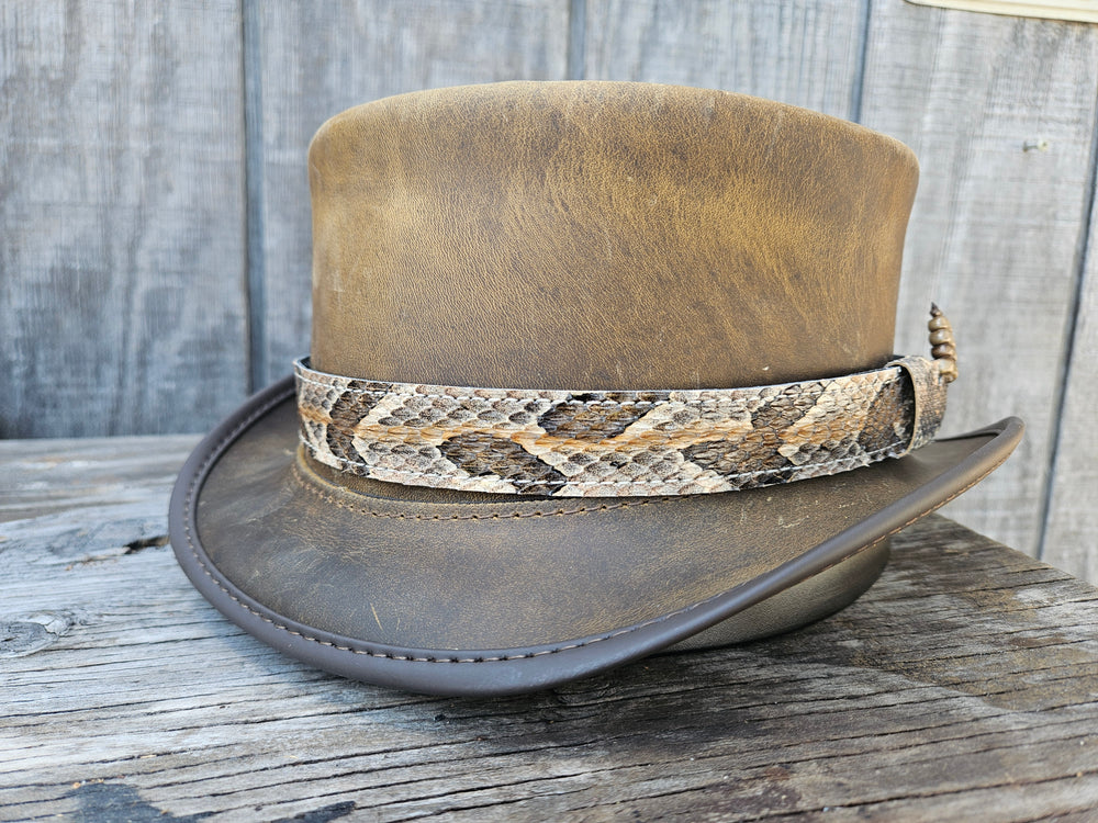 This Natural Copper Canyon Eastern Canebrake Rattlesnake Skin Hatband has a Rattle at the end of the band. It has more a Striped Copper pattern than a traditional Diamondback. Actual snakeskin with a pigskin backing and adjustment with a Velcro loop that you can tighten or loose to fit your favorite hats. You can bring your hat and try them out if you come to our Smyrna, TN shop not far from Nashville.

1" width