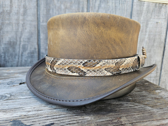 This Natural Copper Canyon Eastern Canebrake Rattlesnake Skin Hatband has a Rattle at the end of the band. It has more a Striped Copper pattern than a traditional Diamondback. Actual snakeskin with a pigskin backing and adjustment with a Velcro loop that you can tighten or loose to fit your favorite hats. You can bring your hat and try them out if you come to our Smyrna, TN shop not far from Nashville.

1" width