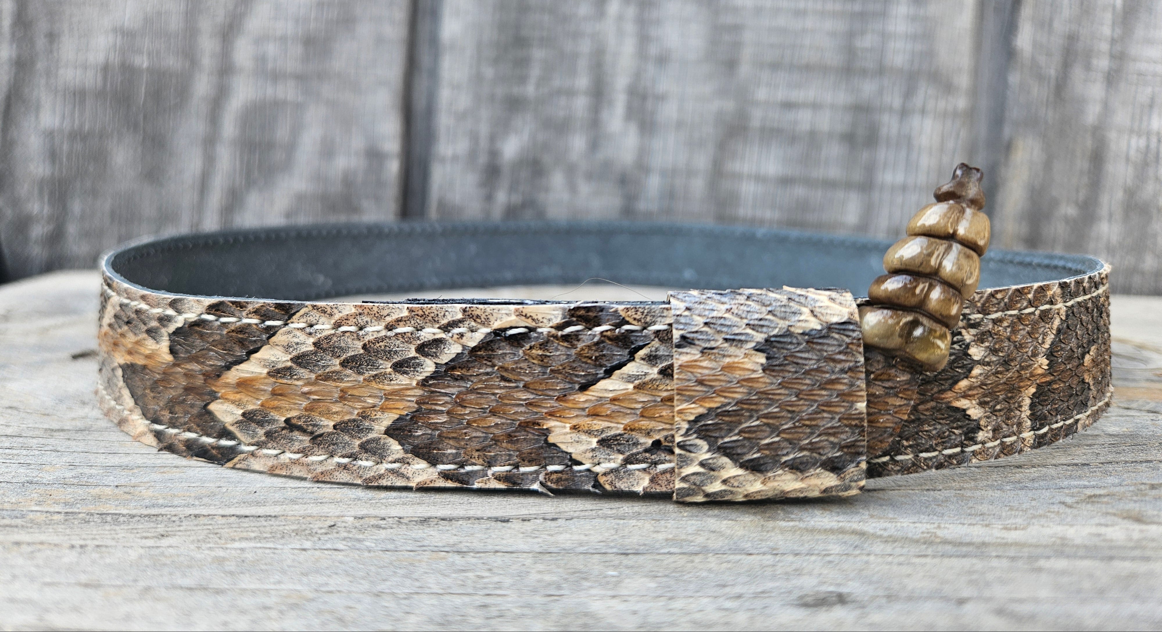 This Natural Southern Rattler Eastern Canebrake Rattlesnake Skin Hat band has a more striped copper pattern than a traditional Diamondback. It has an up-turned Rattle at the end of the band. Hook & loop adjustment to tighten or loosen with sliding keeper. Actual snakeskin with a pigskin backing. Great look for your favorite hats. You can bring your hat and try them out if you come to our Smyrna, TN shop not far from Nashville.

