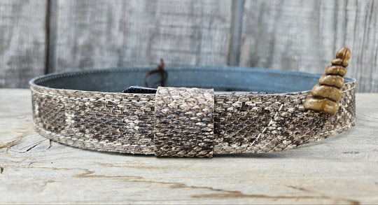 This is a Western Diamondback Snake Skin Hatband. The Western pattern is a little less defined than the Eastern or a Canebrake. The have a Rattler at the of the band that points up slightly and will connect together with a velcro adjustmentand a sliding keeper. Authentic Rattlesnake skin with a pigskin back. Of course you can pick them out if you come to our Smyrna, TN shop not far from Nashville.