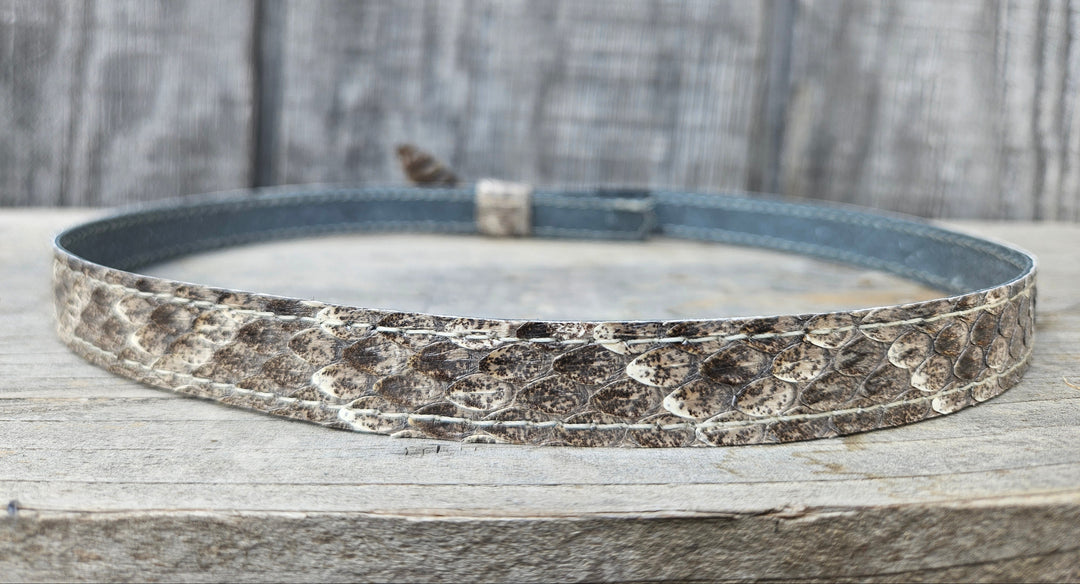 This is a Western Diamondback Snake Skin Hatband. The Western pattern is a little less defined than the Eastern or a Canebrake. The have a Rattler at the of the band that points up slightly and will connect together with a velcro adjustmentand a sliding keeper. Authentic Rattlesnake skin with a pigskin back. Of course you can pick them out if you come to our Smyrna, TN shop not far from Nashville.