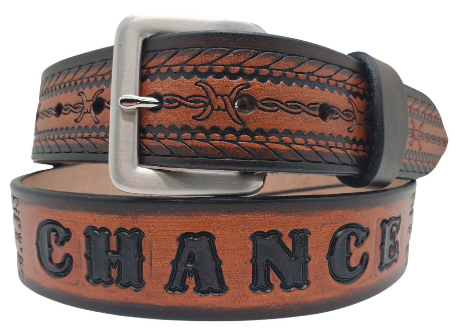 Get ready for an unforgettable adventure with The "Stampede" Name Belt! This one-of-a-kind belt features a 1 1/2" width and is hand-stained with a strip of vegetable tanned leather. The bold design includes a Rope border and Barbwire center pattern, while the solid brass buckle in antique nickel finish adds a touch of ruggedness. Handcrafted at our shop in Smyrna, Tennessee, just outside Nashville.