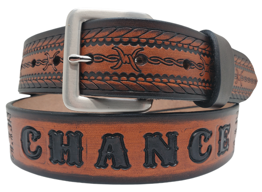 Get ready for an unforgettable adventure with The "Stampede" Name Belt! This one-of-a-kind belt features a 1 1/2" width and is hand-stained with a strip of vegetable tanned leather. The bold design includes a Rope border and Barbwire center pattern, while the solid brass buckle in antique nickel finish adds a touch of ruggedness. Handcrafted at our shop in Smyrna, Tennessee, just outside Nashville.