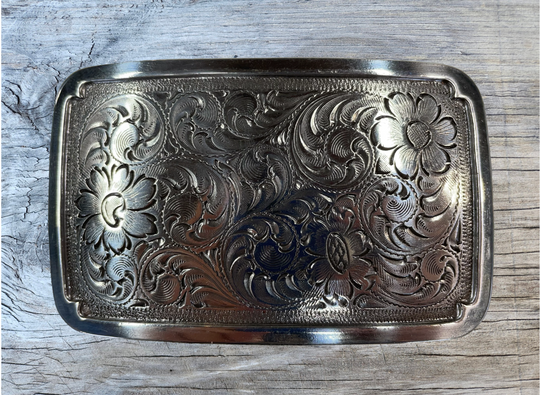 Rectangular antique silver colored belt buckle with Western style tooling, approx. size is 3 1/4" wide by 2" tall. Belt is made from zinc and is imported. Available online and at our shop just outside Nashville in Smyrna, TN.