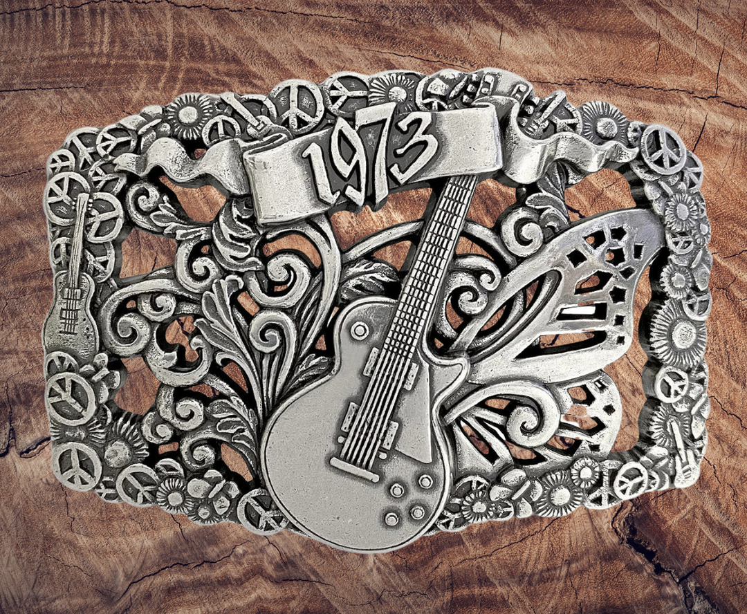 We named this after The 1973 concert featuring The Grateful Dead, Allman Brothers, &amp; The Band: and a HUGE crowd. The buckle has A Filigreed Butterfly, Peace signs, Les Paul guitar, Scroll and Flower designs in Antique Nickel color that looks great on plain 1 1/2" Black or Brown belt. A easy to wear oval shape that&