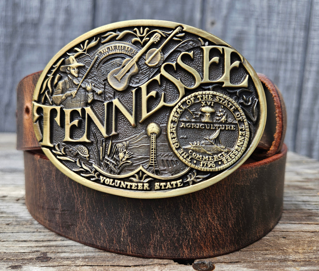 This Tennessee Belt with Montana Silversmith Buckle makes a great Combo. Features a 1 1/2" strap. Choose color: Distressed Brown or Black. The edges are beveled and finished. Available lengths from 34" to 44". The buckle is an Antiqued brass colored Tennessee State Buckle snapped in place. Belt is handmade in our shop in Smyrna, TN, just outside of Nashville