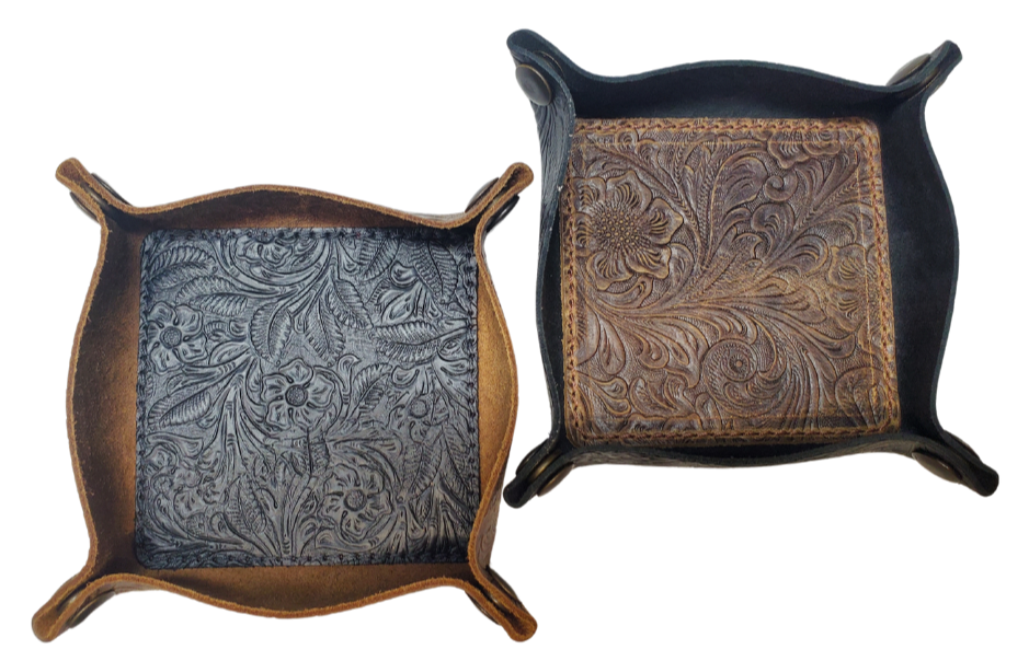 Our Western Leather Valet Tray, crafted in Smyrna, TN, easily folds flat by unsnapping its four Antique Brass snaps—perfect for travel. Its handy 4" x 4" size keeps your everyday essentials like keys and wallet organized. Featuring a classic embossed floral design, it pairs effortlessly with any style. Pick your favorite from four Black and Brown combos! Colors my vary.