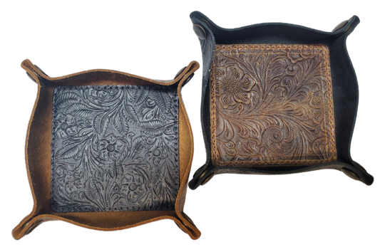 Our Western Leather Valet Tray, crafted in Smyrna, TN, easily folds flat by unsnapping its four Antique Brass snaps—perfect for travel. Its handy 4" x 4" size keeps your everyday essentials like keys and wallet organized. Featuring a classic embossed floral design, it pairs effortlessly with any style. Pick your favorite from four Black and Brown combos! Colors my vary.