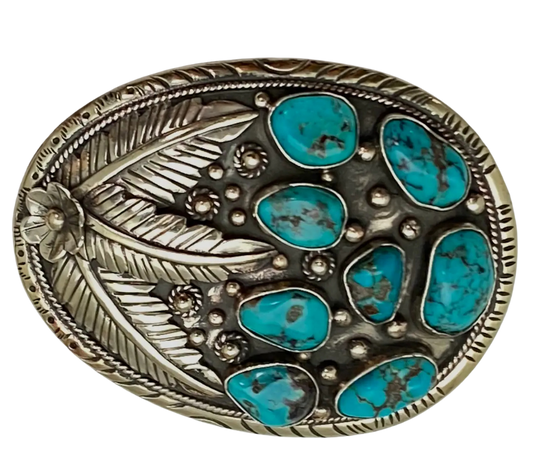 The Navajo influenced Turquoise Sky belt buckle&nbsp; It is crafted from white metal with turquoise and flowers on it and no 2 are alike because of the unique stones in each buckle. The measurement is approx. 3"x 4" and will fit up to 1 1 /2" belts. Ride on to our Smyrna, TN shop and check'em out!

Handcrafted in Nepal.
Floral design back