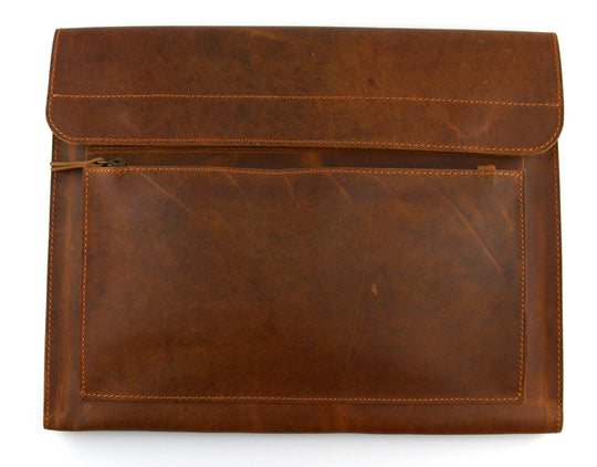 The Analyst is a tablet or thin laptop sleeve handmade from full-grain leather. A practical gift idea for yourself, family, or friends. Offered in a 13" or a 15". Side gussets extend approximately 3/4 inches on each side for both the main pocket and the accessory pocket. Distressed brown leather with antique brass magnet closures and zipper. Part of our Home Office items now at our Smyrna, TN shop.