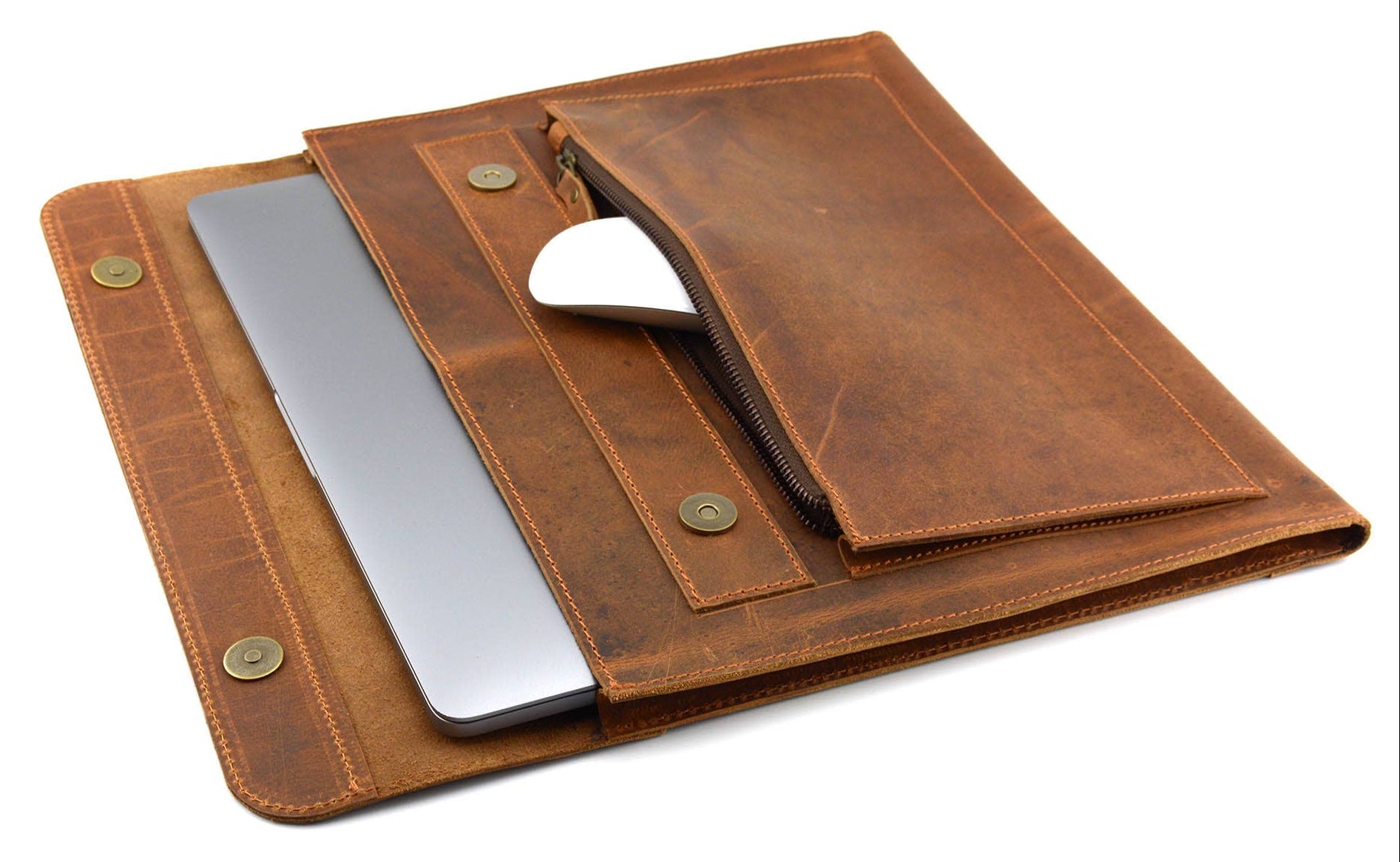 The Analyst is a tablet or thin laptop sleeve handmade from full-grain leather. A practical gift idea for yourself, family, or friends. Offered in a 13" or a 15". Side gussets extend approximately 3/4 inches on each side for both the main pocket and the accessory pocket. Distressed brown leather with antique brass magnet closures and zipper. Part of our Home Office items now at our Smyrna, TN shop.