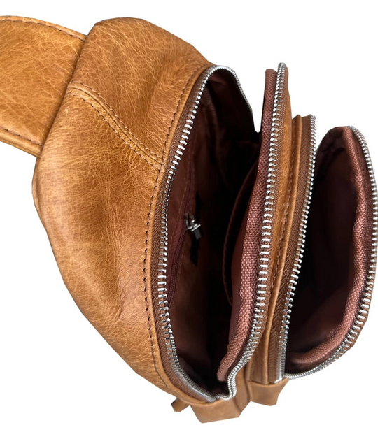 The Daily Carry Sling bag has two spacious main compartments. One main compartment has Interior throw pocket and 1 zipper pocket 1 exterior vertical zipper pocket on front side for your accessories. Backside has 1 vertical zipper pocket Metal loops are to adjust which side the strap attaches Adjustable shoulder strap, Leather pulls

Material: Cowhide leather Colors: black, cream, light brown
Size: 11 ¼”x 6½”x 3”