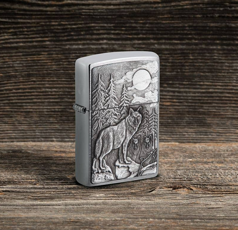 This Brushed Chrome windproof lighter has an emblem attached displaying a timber wolves in the wilderness. All metal construction; windproof design works virtually anywhere. Refillable for a lifetime of use. Comes packaged in a gift box. Available in our Smyrna, TN shop.

Made in USA
Fuel: Zippo lighter fuel (sold separately)
Lighter Specs: Height: 2.25" Width: 0.5" Depth: 1.5" Weight: 2.0 oz
Lifetime guarantee that "it works or we fix it free™" Zippo contact info on gift box.