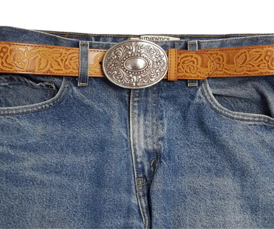 The "Victorian" buckle features an oval design adorned with western-style flowers framing a beaded oval center that resembles a rustic, unpolished mirror. It fits a standard 1 1/2" belt and measures about 2 1/2" by 3 3/4". Finished in antique silver, this charming buckle is ready to add a touch of vintage flair. Grab yours online or visit us in Smyrna, TN, just a stone’s throw from Nashville!