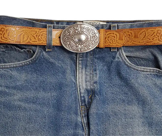 The "Victorian" buckle features an oval design adorned with western-style flowers framing a beaded oval center that resembles a rustic, unpolished mirror. It fits a standard 1 1/2" belt and measures about 2 1/2" by 3 3/4". Finished in antique silver, this charming buckle is ready to add a touch of vintage flair. Grab yours online or visit us in Smyrna, TN, just a stone’s throw from Nashville!