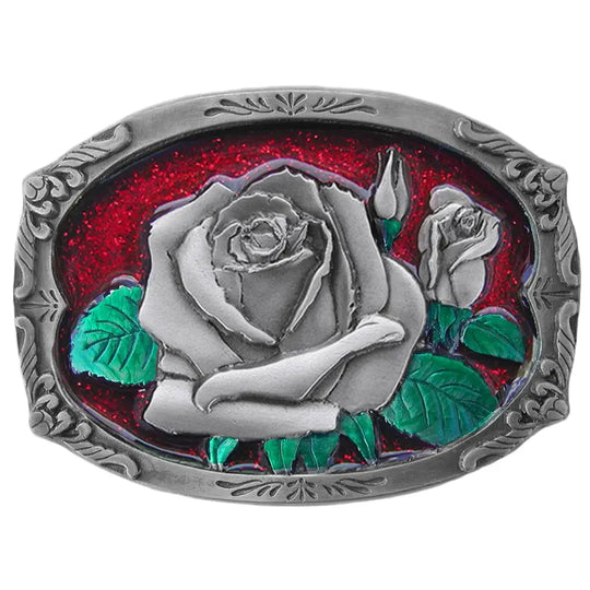 The "Rose Bud" belt buckle showcases a blooming rosebud highlighted with red and green enamel inlays, framed by a delicate filigree border on a semi-rectangular design. Proudly made in the USA, this solid metal cast buckle measures 2 7/8" by 2 1/16". Crafted from lead-free zinc aluminum and coated with non-toxic epoxy enamel, it fits belts up to 1 3/4" wide. Find this charming buckle in our Smyrna, TN shop just outside Nashville.