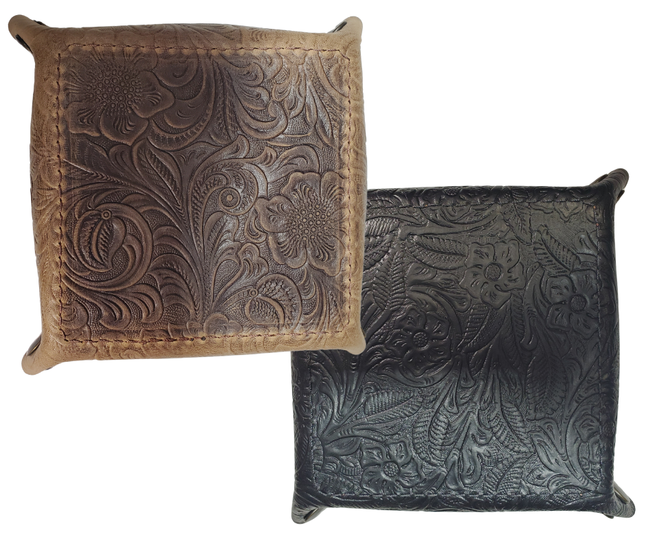Our Western Leather Valet Tray, crafted in Smyrna, TN, easily folds flat by unsnapping its four Antique Brass snaps—perfect for travel. Its handy 4" x 4" size keeps your everyday essentials like keys and wallet organized. Featuring a classic embossed floral design, it pairs effortlessly with any style. Pick your favorite from four Black and Brown combos! Colors my vary.