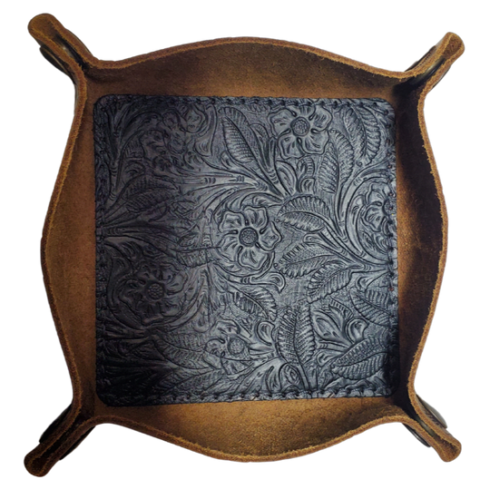 Our Western Leather Valet Tray, crafted in Smyrna, TN, easily folds flat by unsnapping its four Antique Brass snaps—perfect for travel. Its handy 4" x 4" size keeps your everyday essentials like keys and wallet organized. Featuring a classic embossed floral design, it pairs effortlessly with any style. Pick your favorite from four Black and Brown combos! Colors my vary.