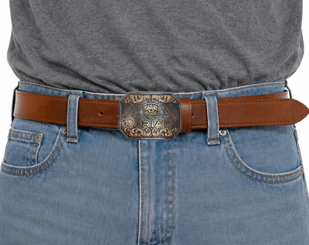 This rectangular shaped buckle has rounded edges and Ariat logo centered on surface. Surface also has scroll and flower designs and rope design around the border of the buckle. Color is antique chrome. Measures 2 1/2" tall by 3 1/2" wide.; Fits belts up to 2" wide. Available for purchase in our online store or the retail shop in Smyrna, TN, just outside Nashville. Imported