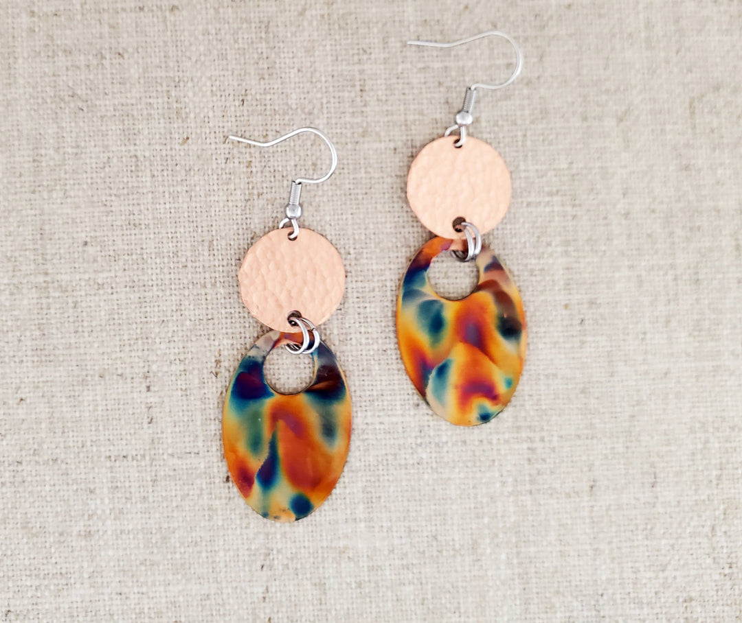 -Hand cut and finished copper blanks that are then flame painted with a torch. The connector piece is hammered for texture. -Sealed to keep the finish -Ear wires are stainless steel. -2 1/2" in length and 3/8" in width -Medium weight -Each pair of earrings will look similar to the above pictured pair, but will vary slightly in color and pattern due to dealing with torch. Stocked at our Smyrna, TN shop down I-24 from downtown.