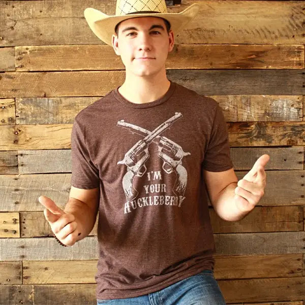 The I'm your Huckleberry line has become one of the most known in Westerns at this point. Get your's in Chocolate Brown with the famous graphic. Available online and in our retail shop in Smyrna, TN. Made of super soft 50% ring spun cotton &amp; 50% poly. Pre-shrunk.