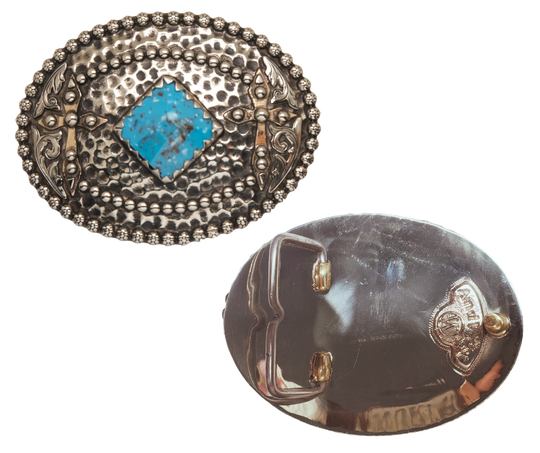 reverse side. Tubal-Cain was the original master behind crafting all your favorite bronze and iron tools. This buckle features a hammered backdrop dotted with rosettes, framed by a beaded metal edge, and sports a diamond-shaped turquoise centerpiece. Each end is decorated with a western scroll and a cross. Measuring about 3"x4", it suits belts up to 1 3/4" wide. Swing by our Smyrna, TN shop to grab yours!