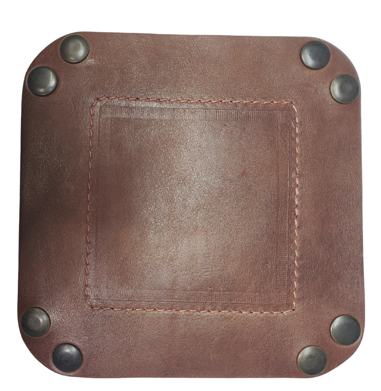The Franklin is a little different than our other trays because of the Hand Stamped and stained inside layer. Outer layer is a Bison brown color with the inside layer being stitched in. The corners are held together with heavy line 24 Antique Brass colored snaps, for laying flat for travel, a place for placing keys, wallet, coins, etc. Made in our shop just outside Nashville in Smyrna, TN.