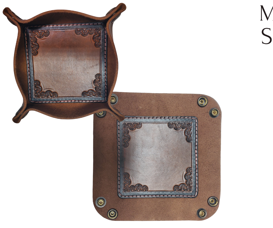 The Franklin is a little different than our other trays because of the Hand Stamped and stained inside layer. Outer layer is a Bison brown color with the inside layer being stitched in. The corners are held together with heavy line 24 Antique Brass colored snaps, for laying flat for travel, a place for placing keys, wallet, coins, etc. Made in our shop just outside Nashville in Smyrna, TN.